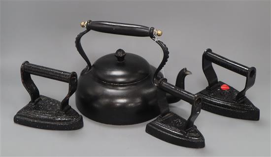 A set of three Victorian brass and iron horse door stops, an iron kettle and three irons